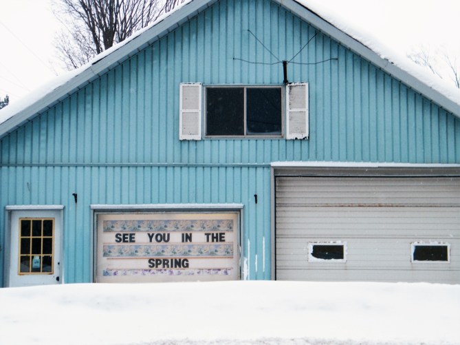With the sign that says "See You In The Spring", people look forward to the bike shop's re-opening in the spring after a long winter.